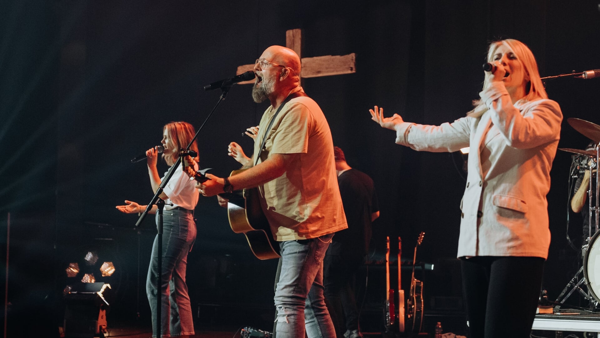 Kees Kraayenoord zingt met Mozaiek Worship, met een houten kruis op de achtergrond