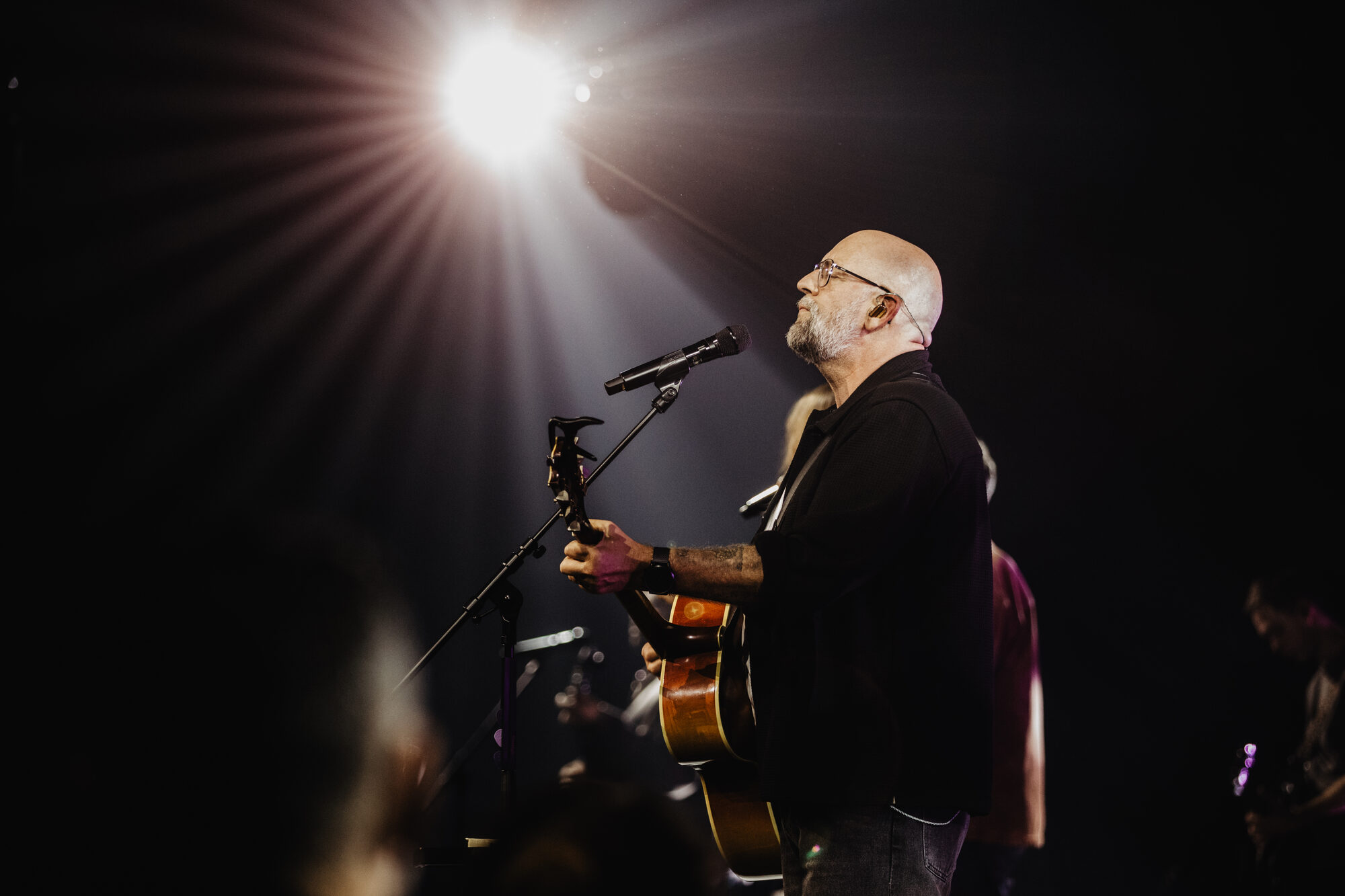 Kees Kraayenoord met akoestische gitaar achter de microfoon tijdens de live-opname van Jezus Messias