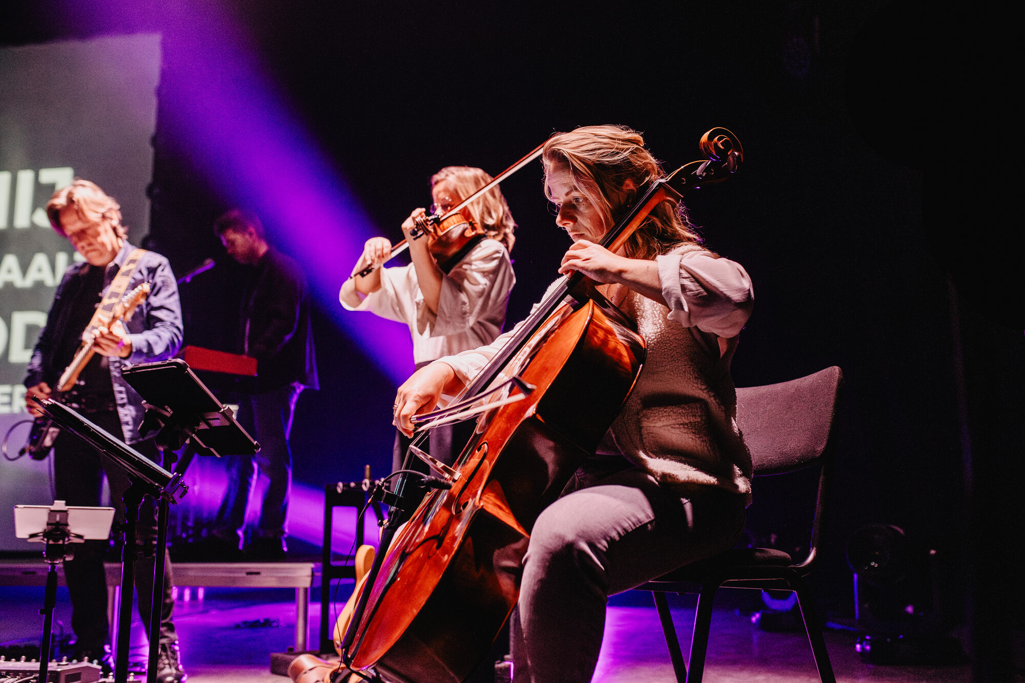 Cellisten van het strijkersensemble op het podium tijdens de live-opname van Jezus Messias