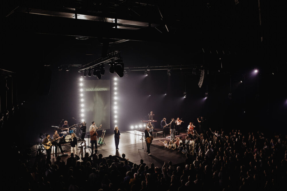 Mozaiek Worship op het podium in paars podiumlicht