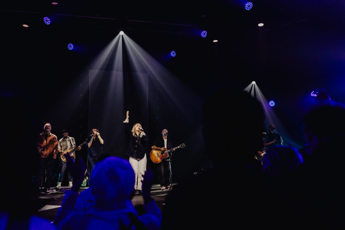 Lichtbalken boven de band van Mozaiek Worship op het podium