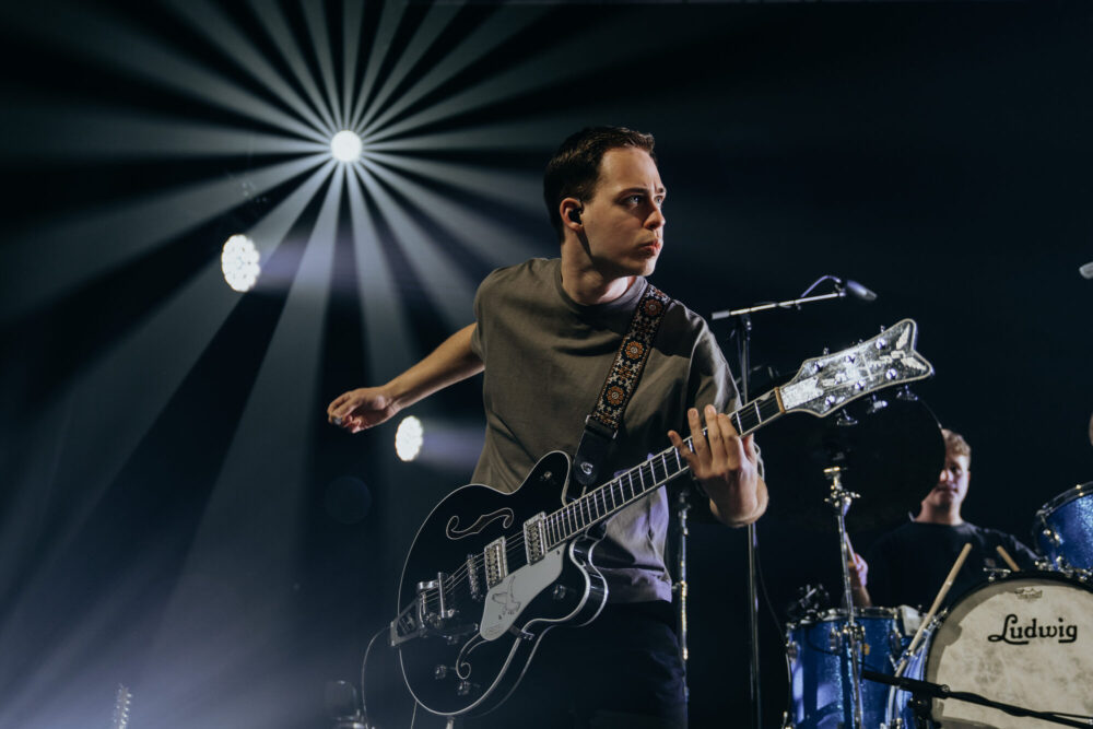 Gitarist van Mozaiek Worship in het podiumlicht tijdens de live-opname
