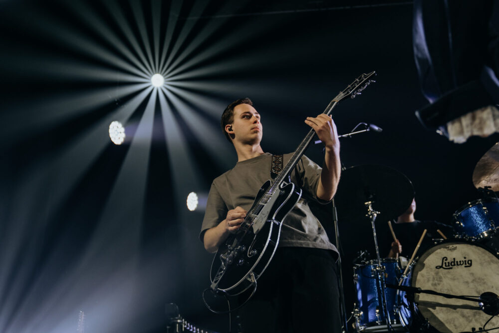 Gitarist met elektrische gitaar op het podium tijdens de live-opname van Jezus Messias