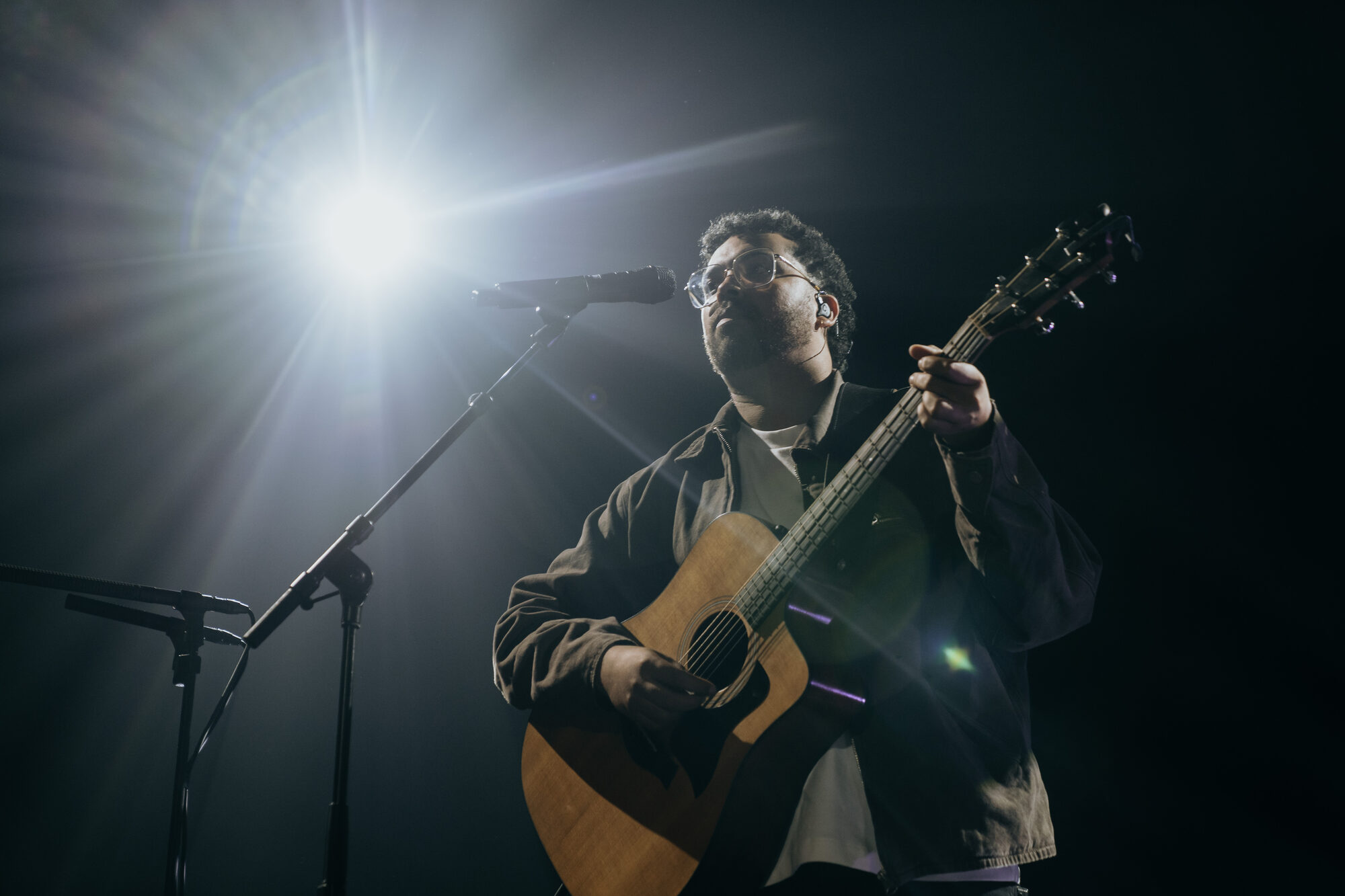 Gitarist met akoestische gitaar in tegenlicht tijdens de live-opname