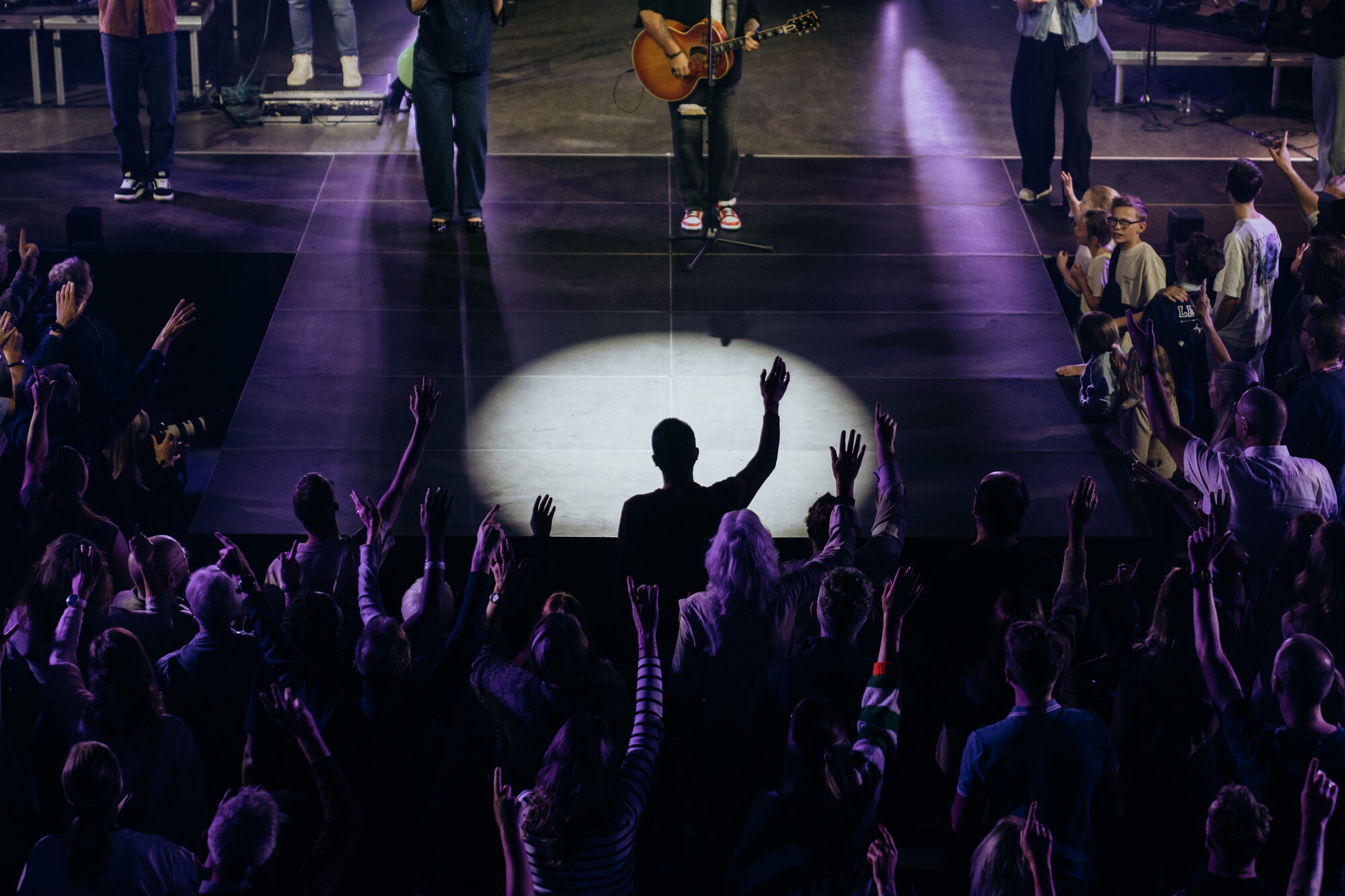 Mozaiek Worship op het podium in blauw podiumlicht