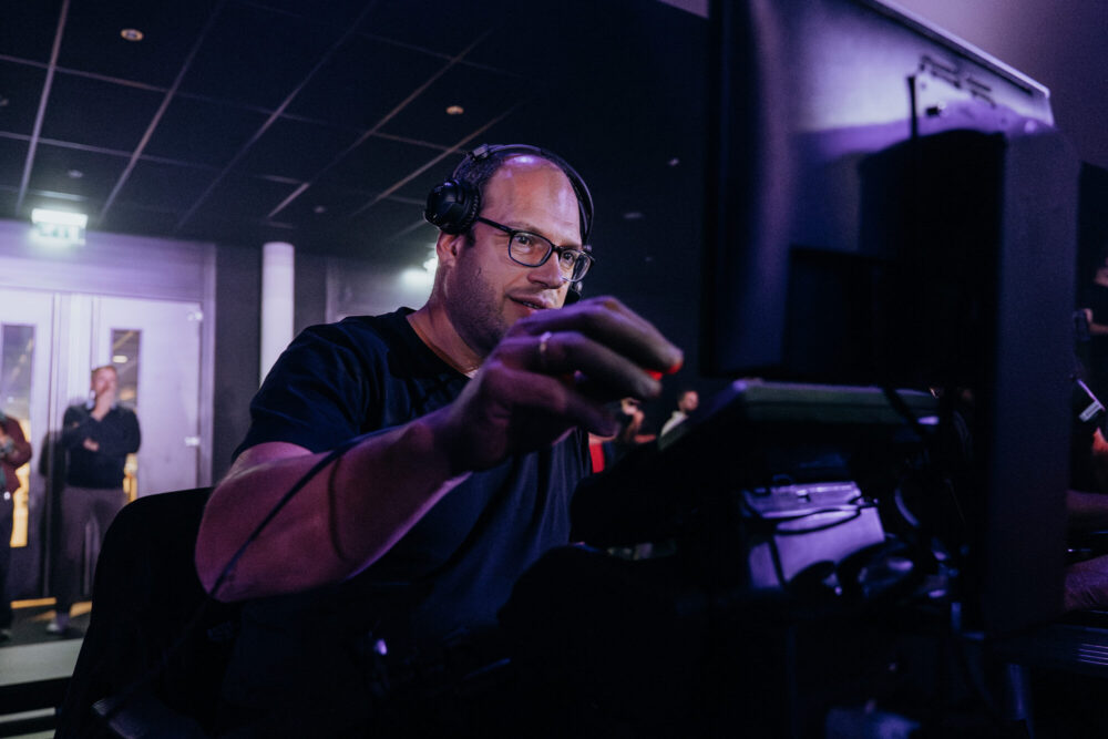 Technicus met koptelefoon aan de knoppen tijdens de live-opname